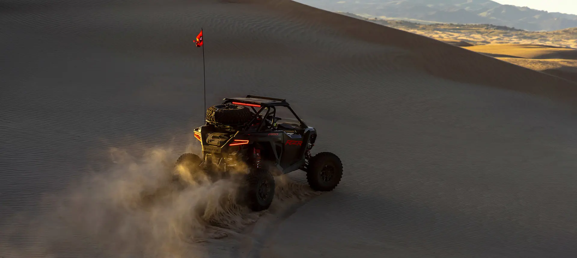 Polaris RZR Pro S side-by-side climbing a hill in the desert.