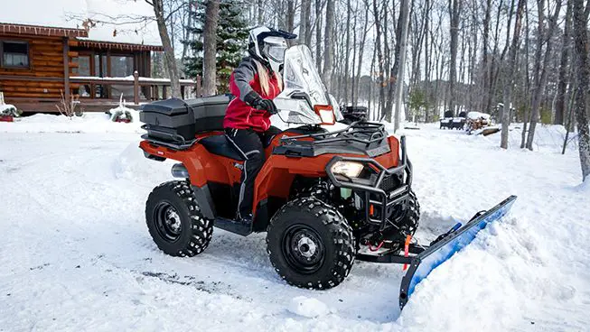 Polaris Sportsman 450 ATV with a plow attached in the winter.