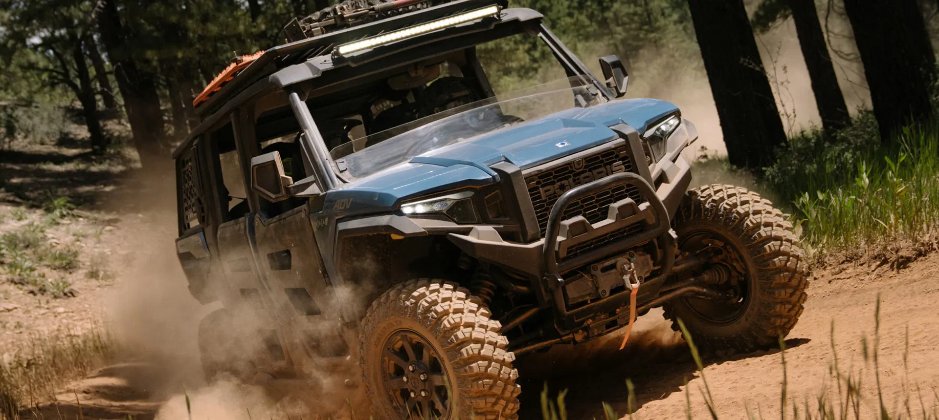 Front end close up of a Polaris XPEDITION ADV 5 side-by-side on a dusty trail.