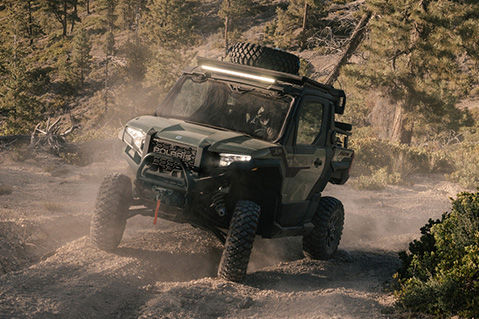 Green Polaris XPEDITION XP with roof rack navigating rocky terrain.