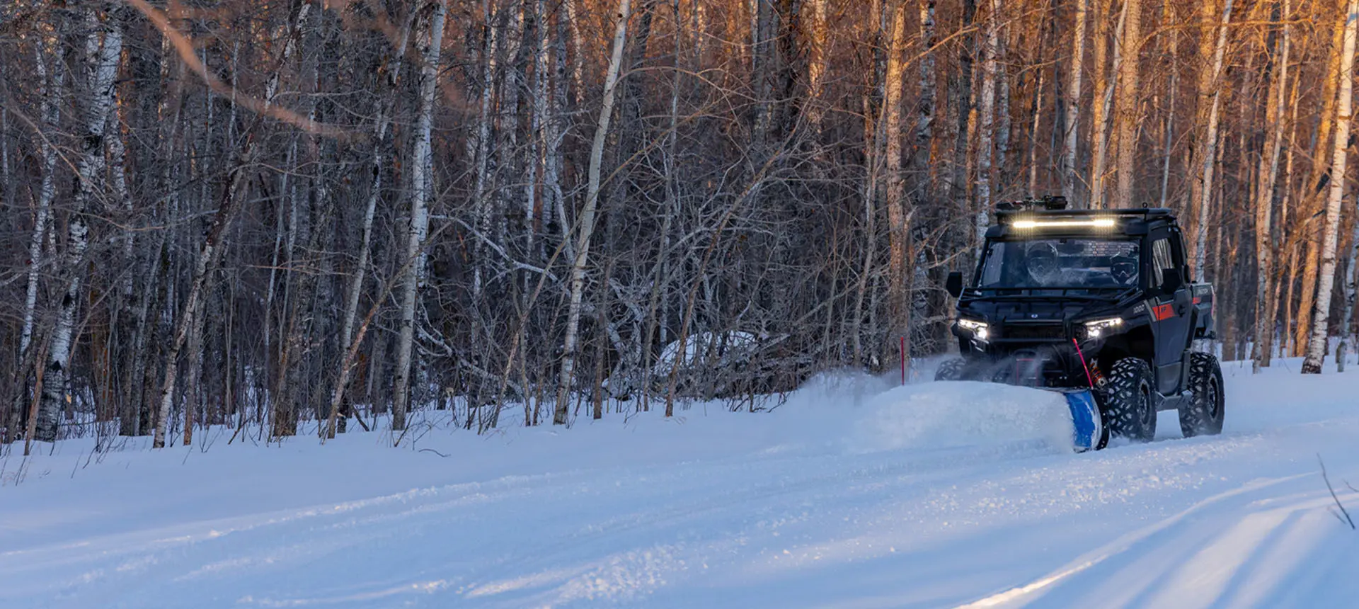 Person plowing snow with a Polaris XPEDITION XP side-by-side with snowplow accessory.