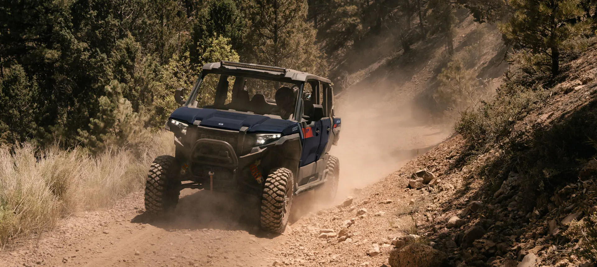 Polaris XPEDITION XP 5 side-by-side driving on a dusty trail.