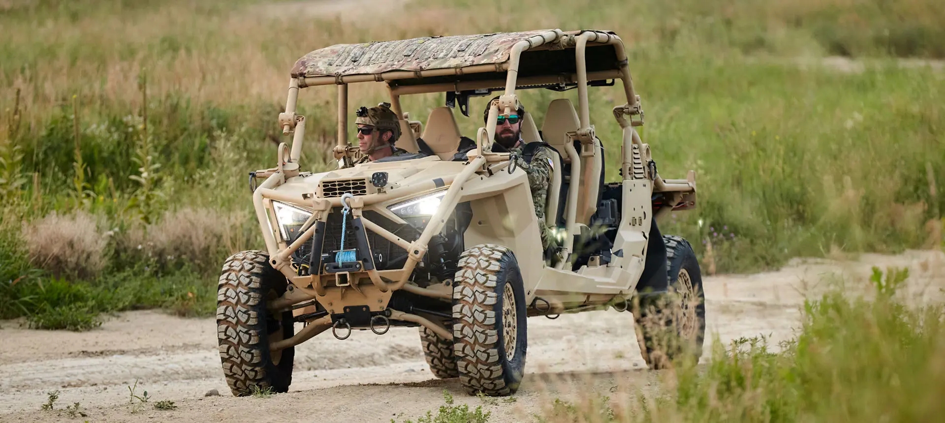 2 soldiers in the passenger seat of a MRZR Alpha military tactical side-by-side that's crawling over rocky terrain.