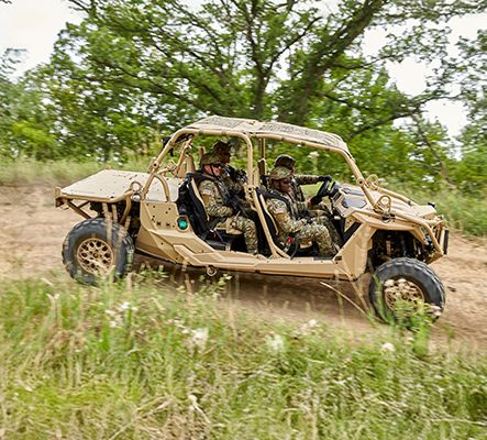 2 soldiers patrolling in a Military Green Polaris MRZR tactical vehicle.