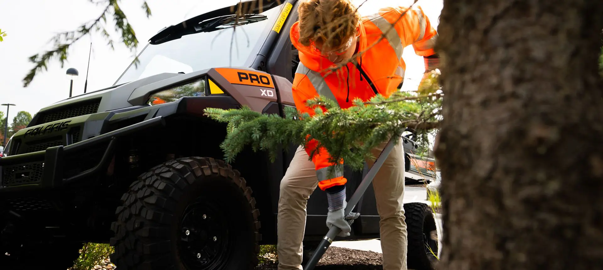 Person shoveling dirt near their Polaris Pro XD Full-Size work UTV.