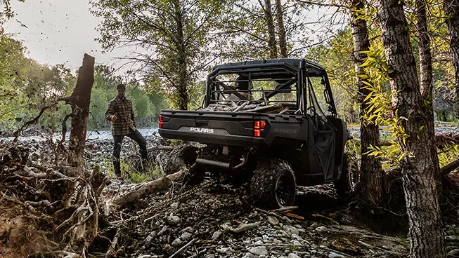 Rear view of a Polaris RANGER 1000 UTV pulling a tree out of the ground.