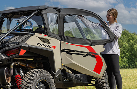 A Polaris RZR Trail side-by-side with canvas upper door accessories installed.