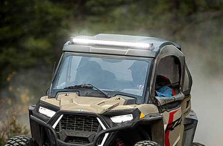 A Polaris RZR Trail side-by-side with lighting accessories installed.