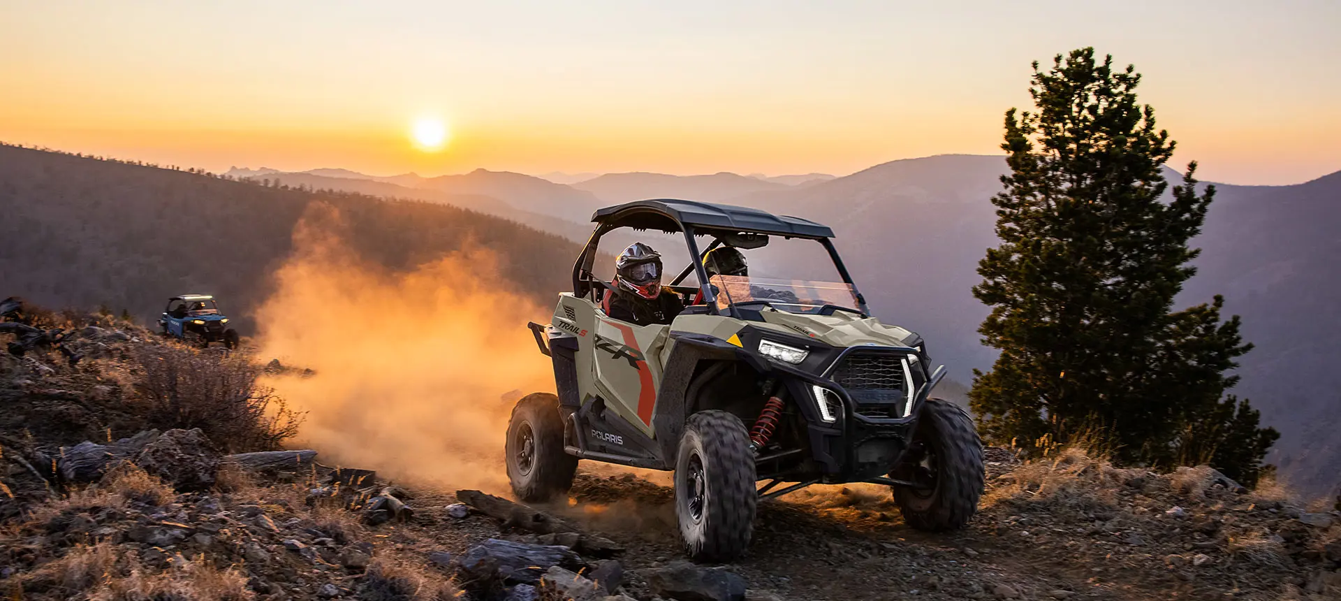 Polaris RZR Trail side-by-side driving at sunrise.
