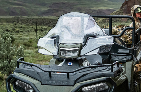 A  Polaris Sportsman 6x6 570 ATV with windshield accessory installed.