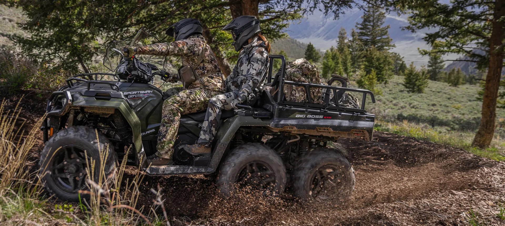 Two hunters riding on a Polaris Sportsman 6x6 570 ATV through mud.