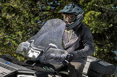 A Polaris Sportsman XP 1000 Ultimate ATV with windshield accessory installed.