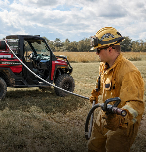 A firefighter pulling out the hose with the Viper Nozzle installed from a RANGER UTV.