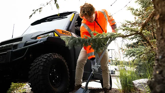 Person digging a hold near their Polaris Pro XD UTV for grounds and facility operations.