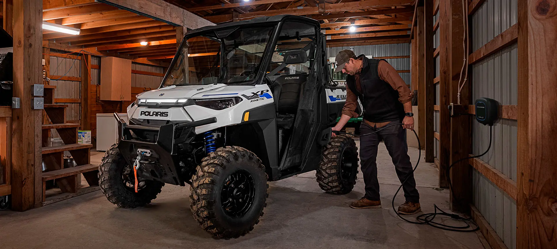Person charging up a Polaris RANGER Kinetic UTV they use for grounds and facility operations.