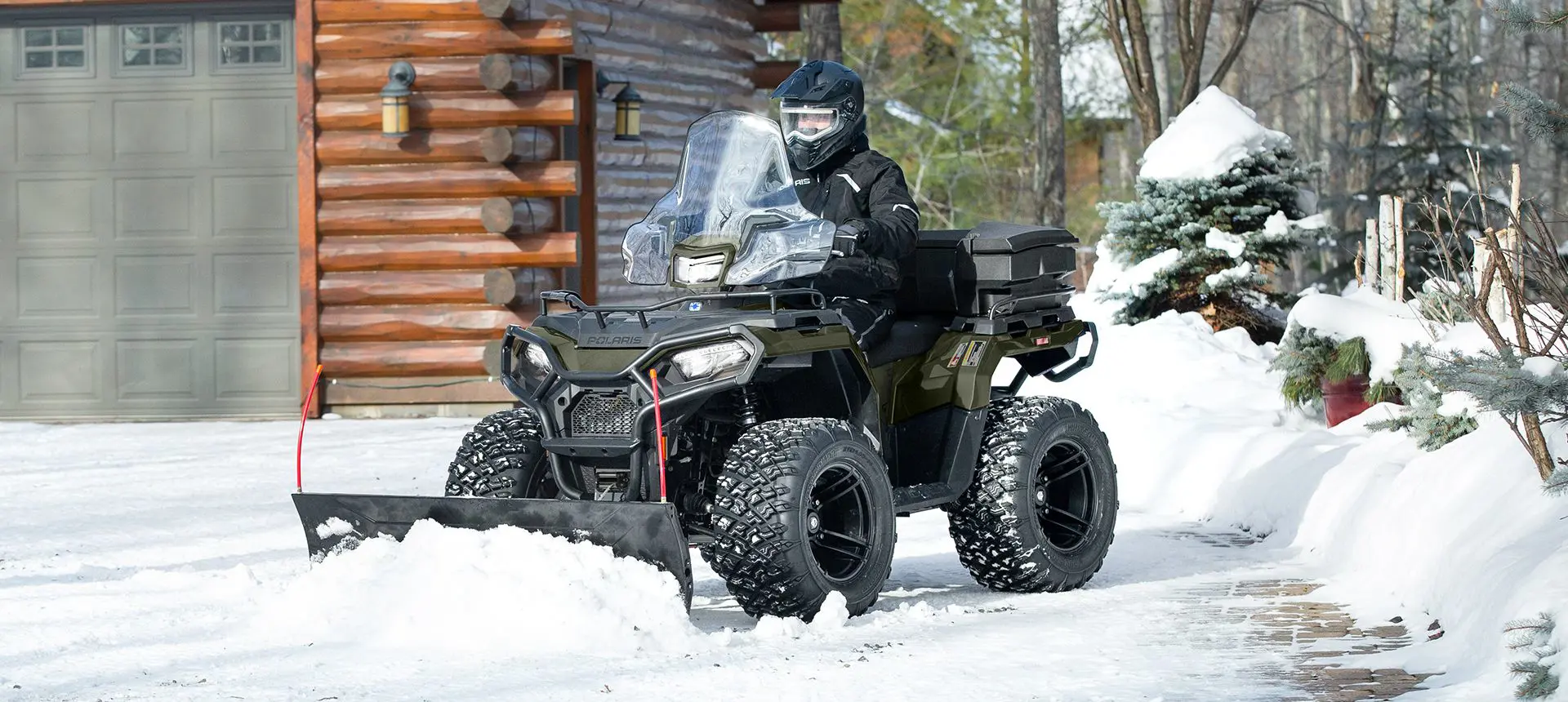 Person using a Polaris Sportsman ATV for snow removal, and grounds and facility operations.