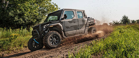 Polaris XPEDITION ADV riding through mud on an off-road trail.