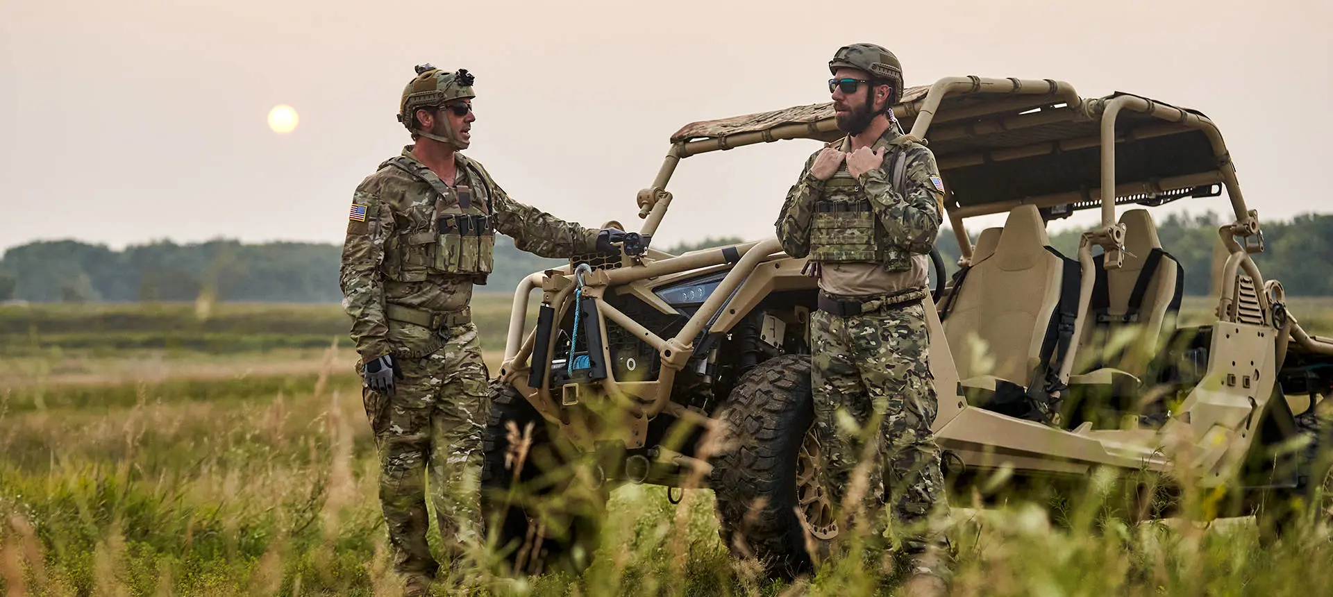 2 soldiers standing near a MRZR Alpha military tactical side-by-side.