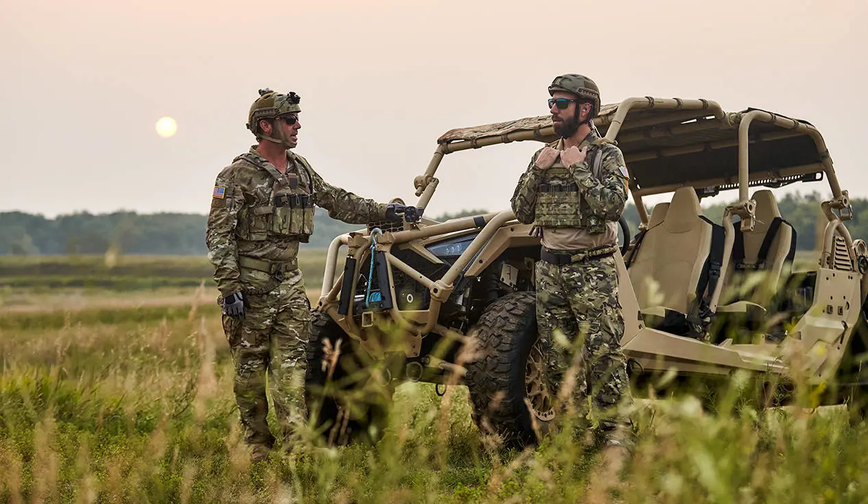2 soldiers standing near a MRZR Alpha military tactical side-by-side.