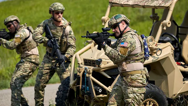 3 soldiers ready for action near an MRZR Alpha XP military tactical side-by-side.