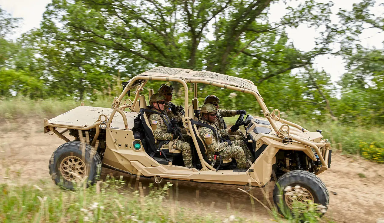 Side profile of 4 soldiers riding in a MRZR Alpha military tactical side-by-side.