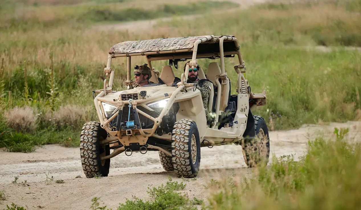2 soldiers in the passenger seat of a MRZR Alpha military tactical side-by-side that's crawling over rocky terrain.