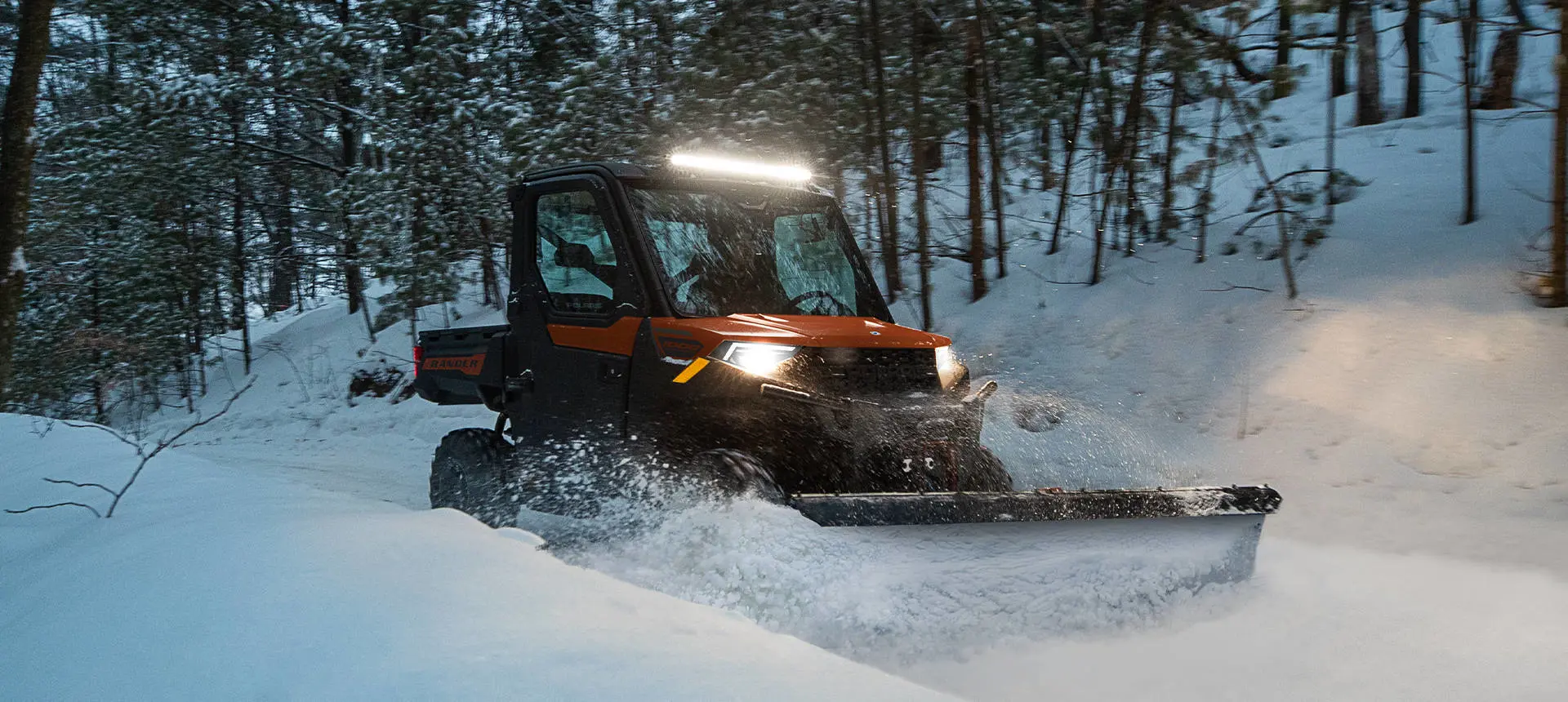 A Polaris RANGER 1000 UTV plowing snow in the winter.