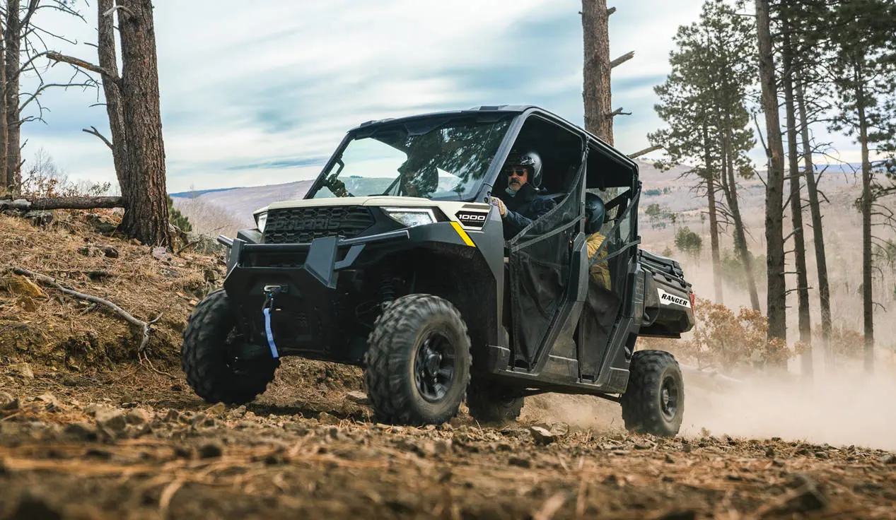 Polaris RANGER CREW 1000 UTV cruising a trail with 4 riders inside.