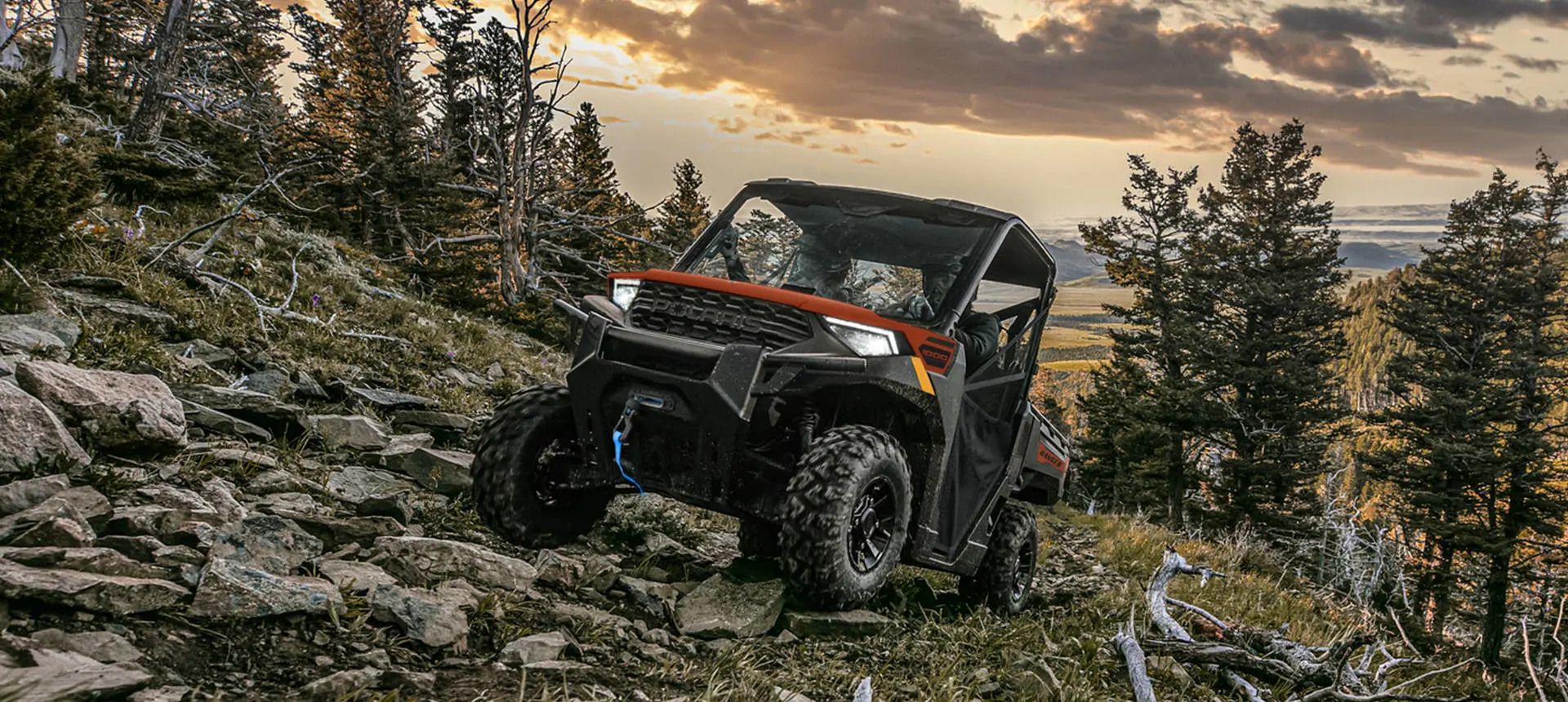 A Polaris RANGER 1000 UTV climbing over rocky terrain.