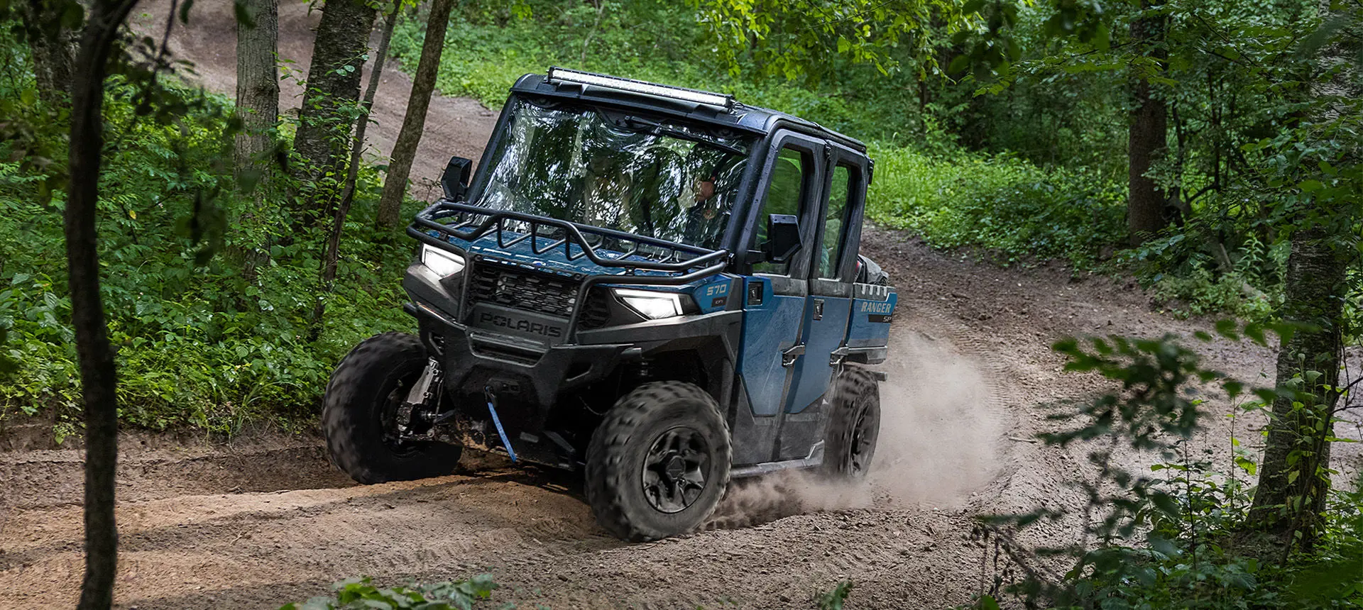 A Polaris RANGER CREW SP 570 NorthStar Edition UTV taking a tight corner on a trail.
