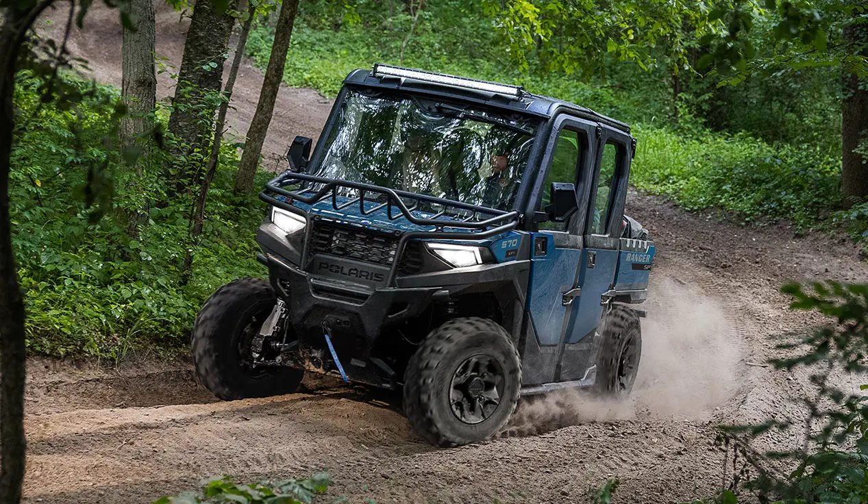 A Polaris RANGER CREW SP 570 NorthStar Edition UTV taking a tight corner on a trail.