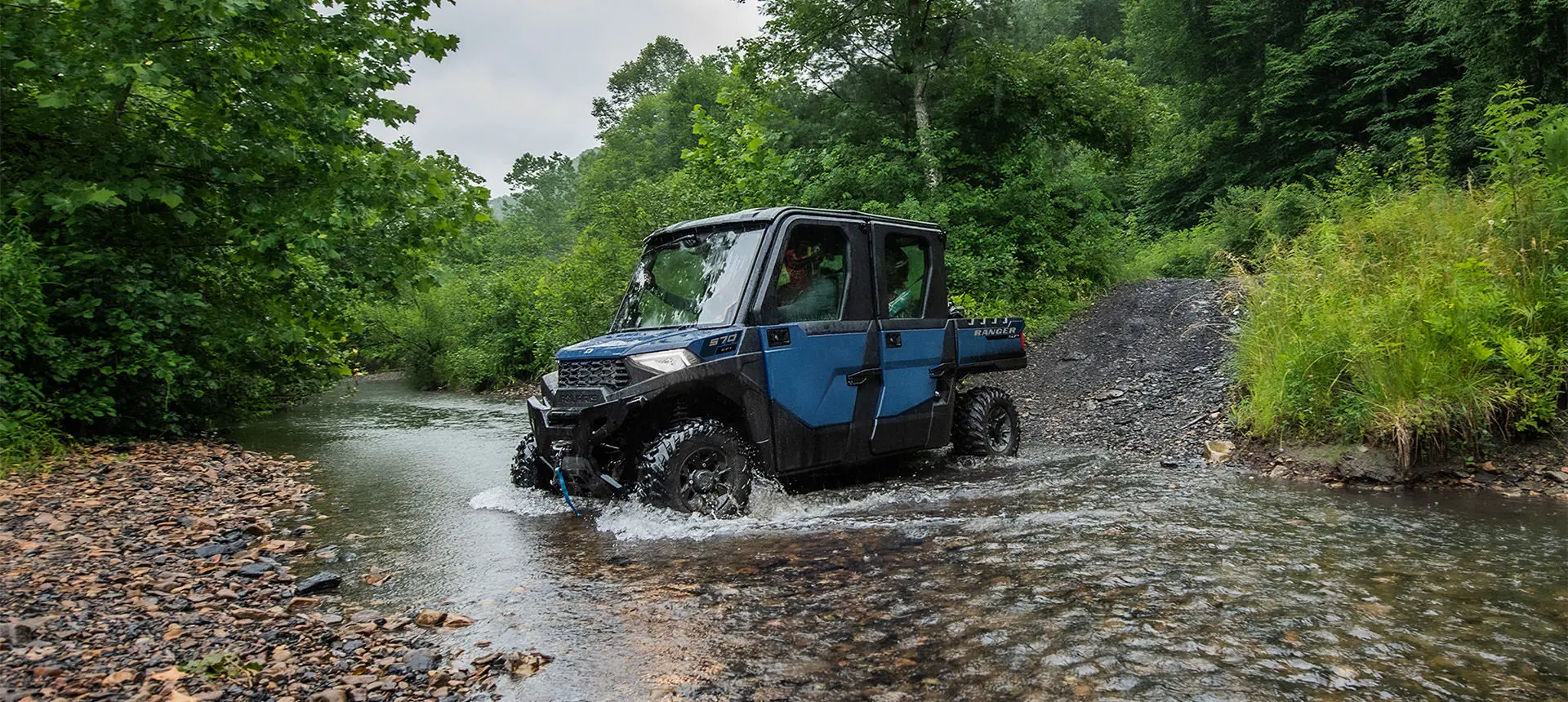 A Polaris RANGER CREW SP 570 NorthStar Edition UTV driving downhill into a ravine.