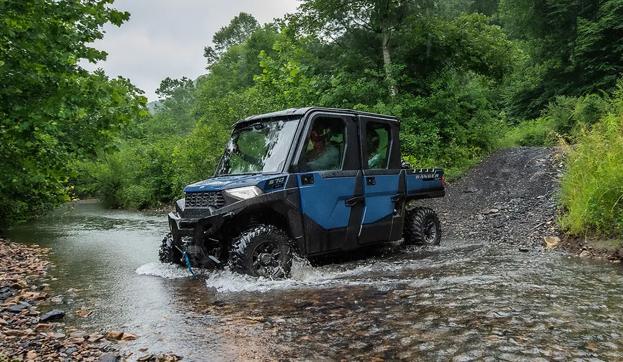 A Polaris RANGER CREW SP 570 NorthStar Edition UTV driving downhill into a ravine.