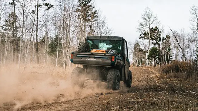 Rear-view of a Polaris RANGER XP 1000 NorthStar Edition UTV on a dusty trail.