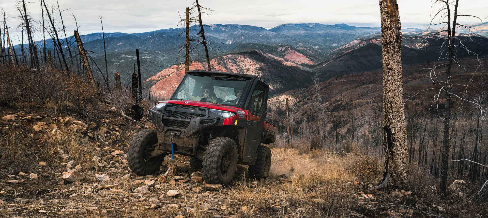 A Polaris RANGER XP 1000 NorthStar Edition UTV climbing uphill over rocky terrain.