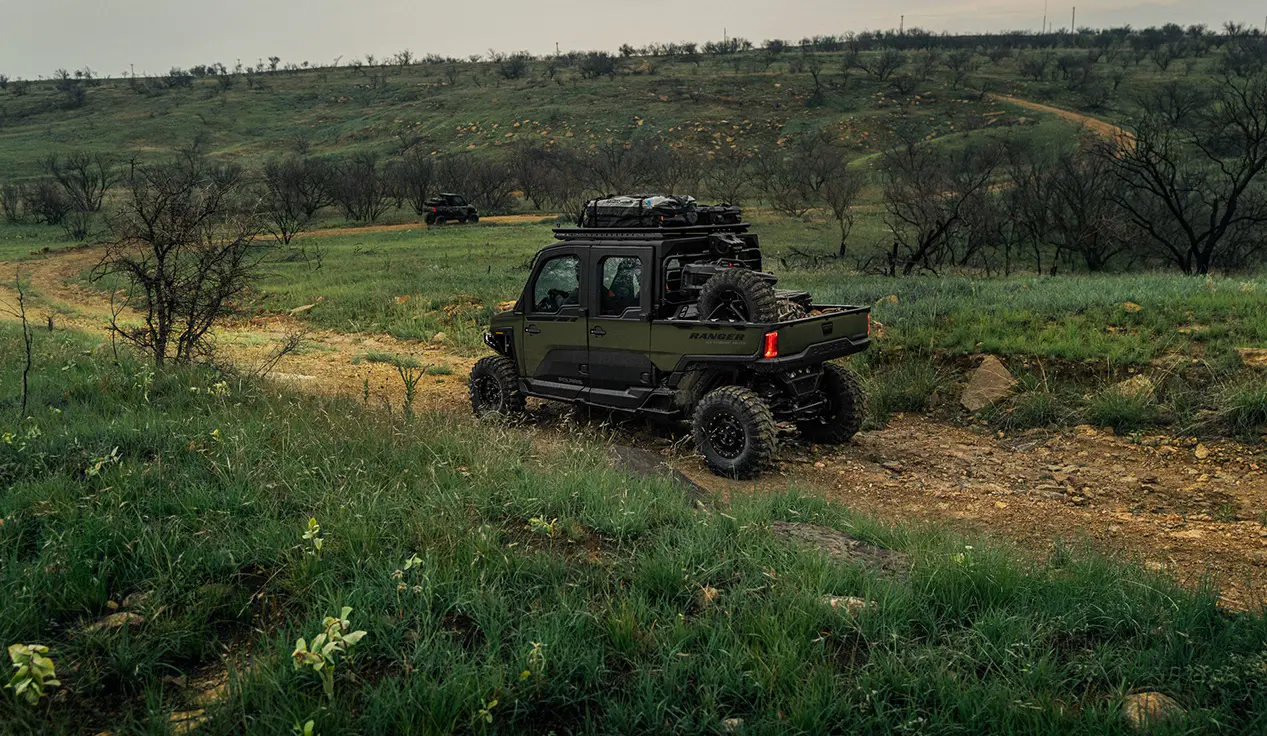 Side view of a Polaris RANGER CREW XD 1500 NorthStar Edition extreme duty UTV cruising on a trail.