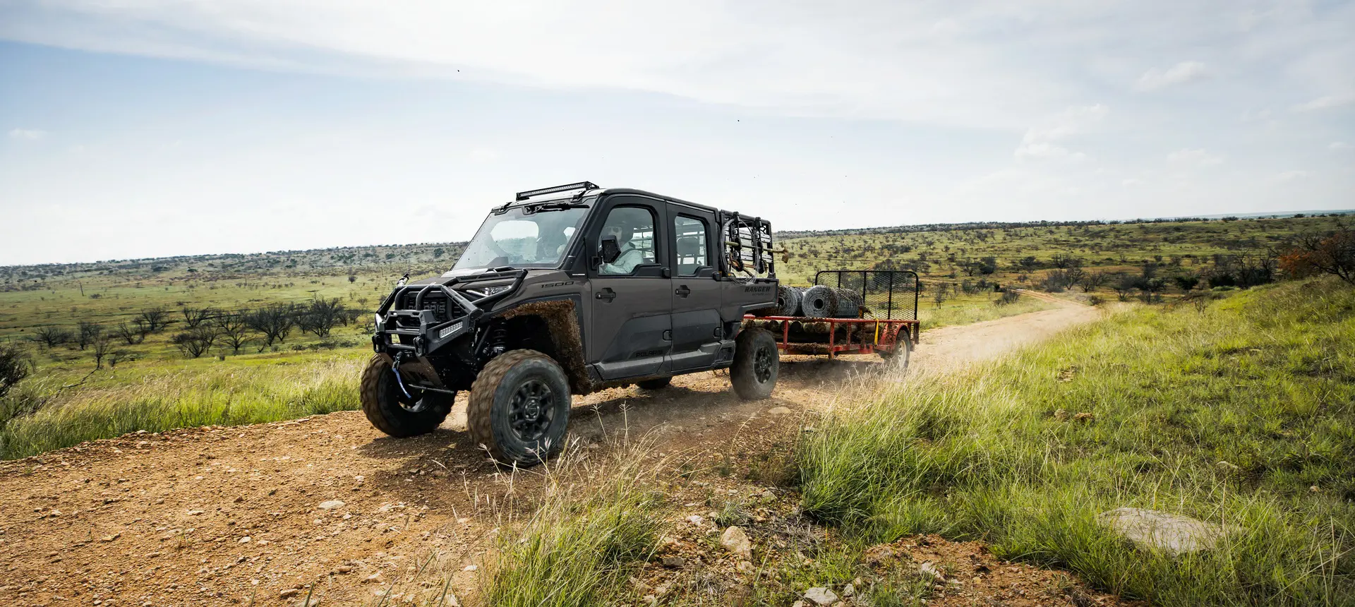 A Polaris RANGER CREW XD 1500 NorthStar Edition extreme duty UTV pulling a heavy trailer.