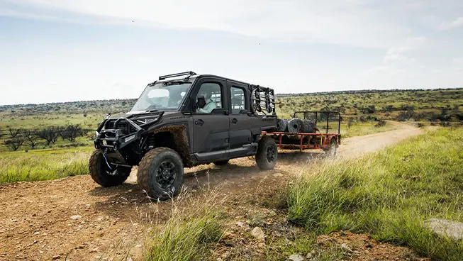 A Polaris RANGER CREW XD 1500 NorthStar Edition extreme duty UTV pulling a heavy trailer.