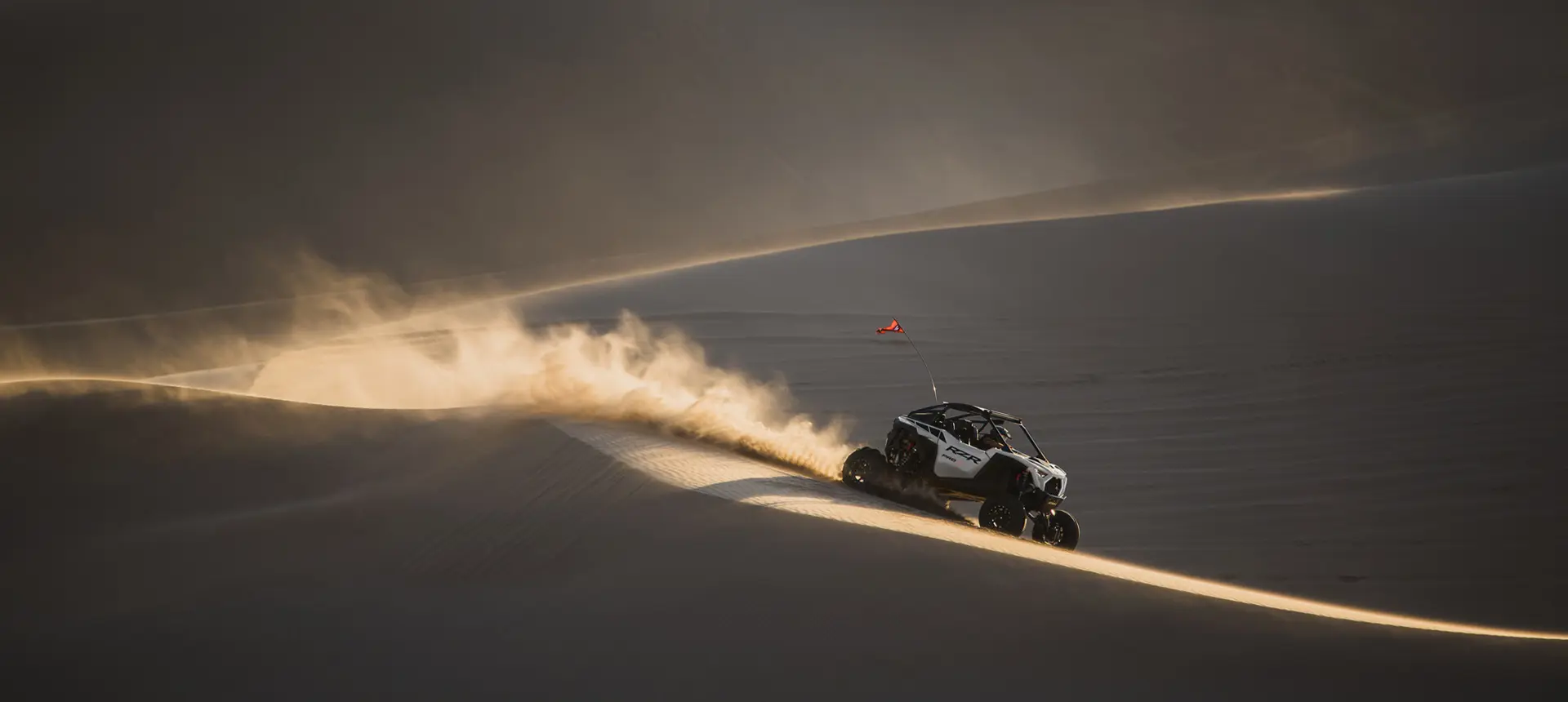 A Polaris RZR Pro R side-by-side cruising through the dunes.