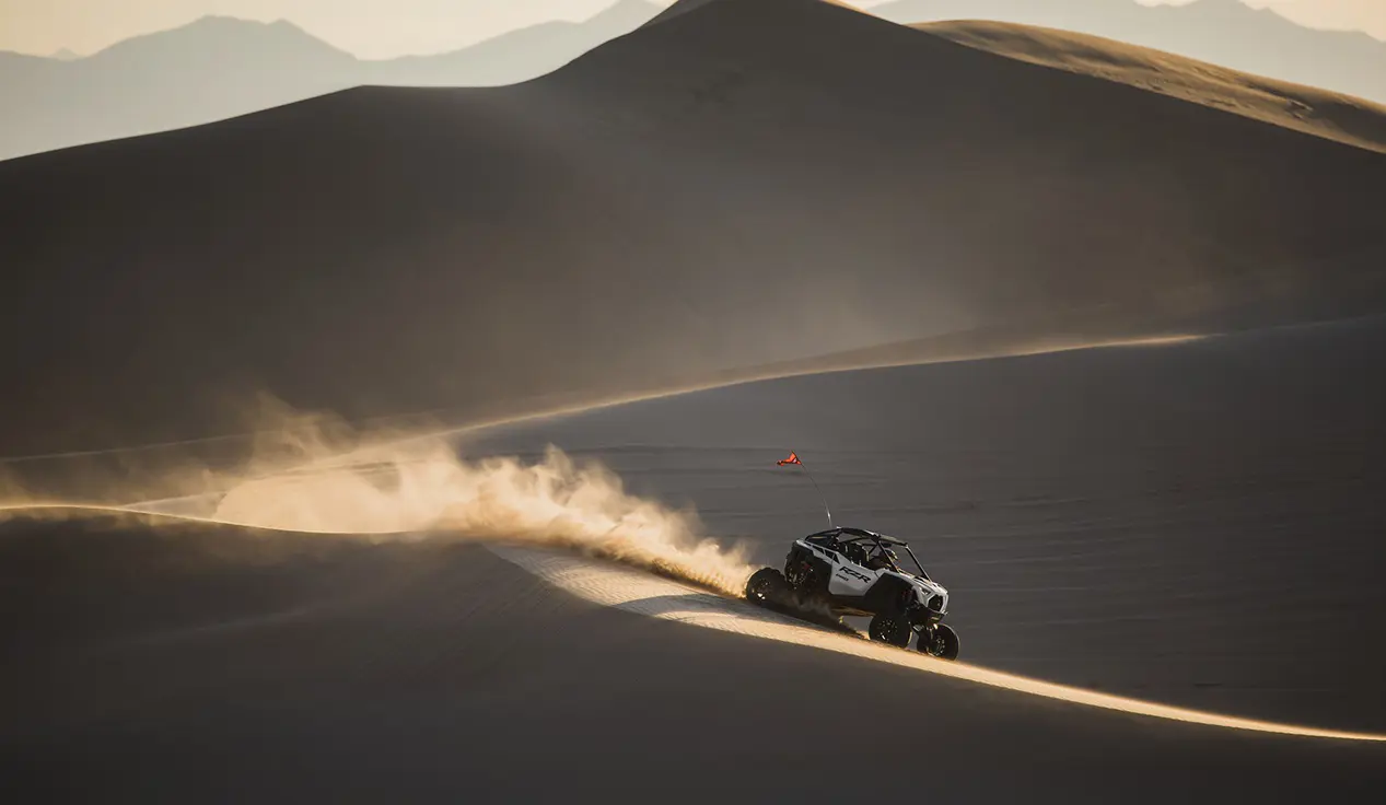 A Polaris RZR Pro R side-by-side cruising through the dunes.