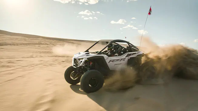A Polaris RZR Pro R side-by-side driving through the desert.