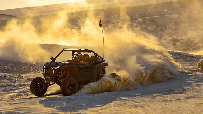 A Polaris RZR Pro R side-by-side throwing sand in the dunes.