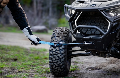 A winch being pulled out of the front end of a Polaris RZR Pro XP side-by-side.