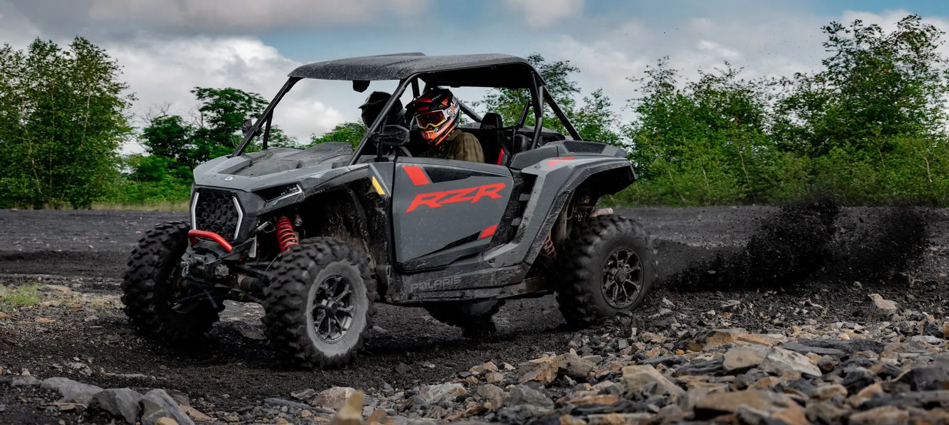 RZR XP side-by-side throwing sand on a dirt trail.