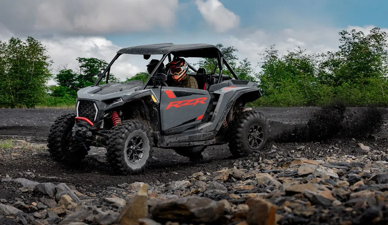 RZR XP side-by-side throwing sand on a dirt trail.