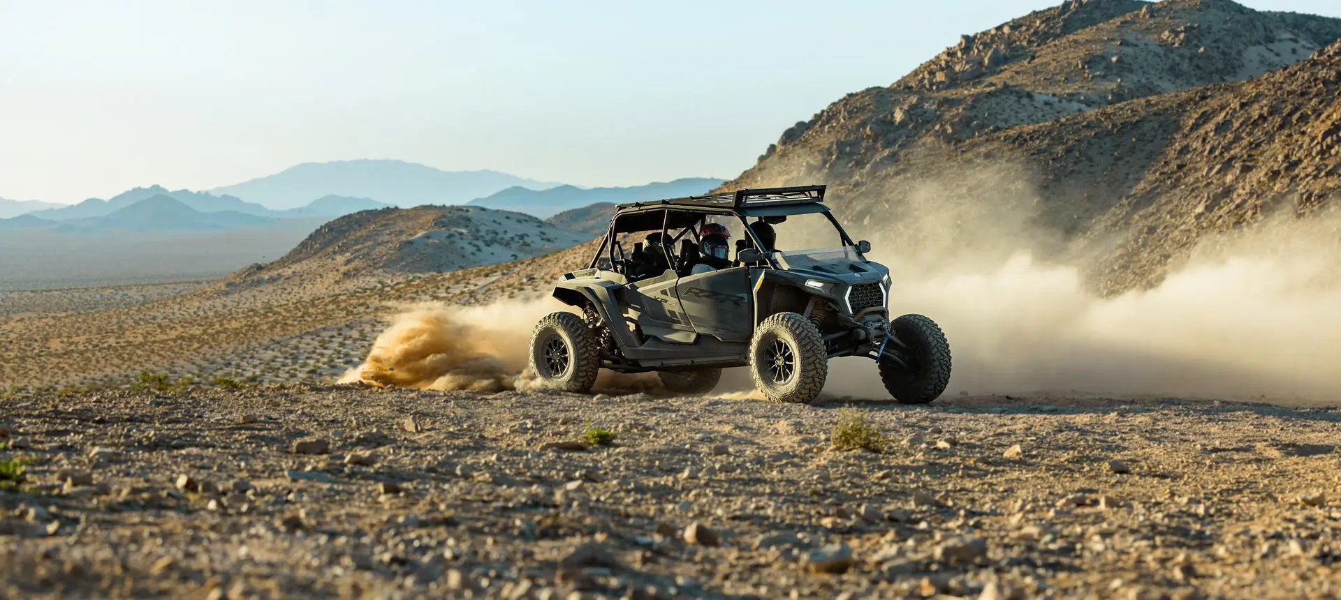 A RZR XP S 4 side-by-side driving through the desert.