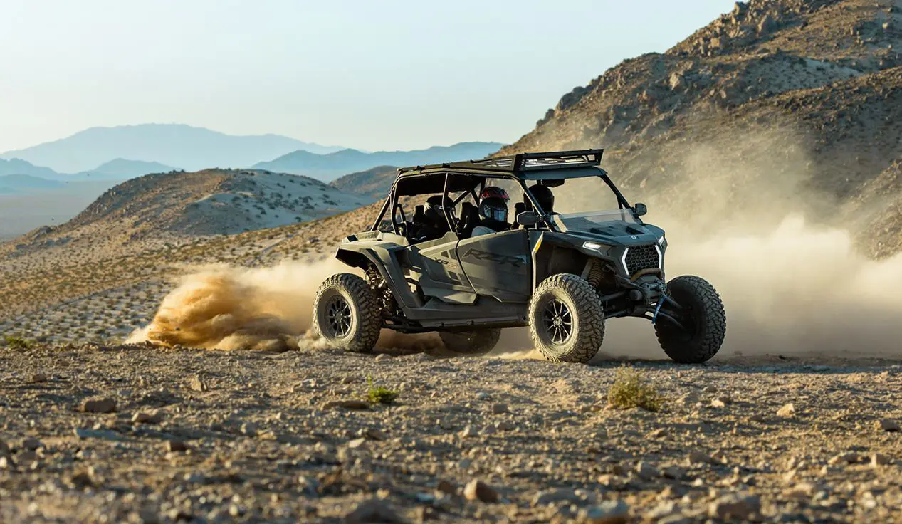 A RZR XP S 4 side-by-side driving through the desert.