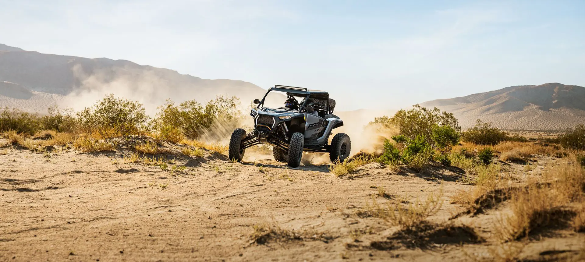 A RZR XP S side-by-side driving through the desert.