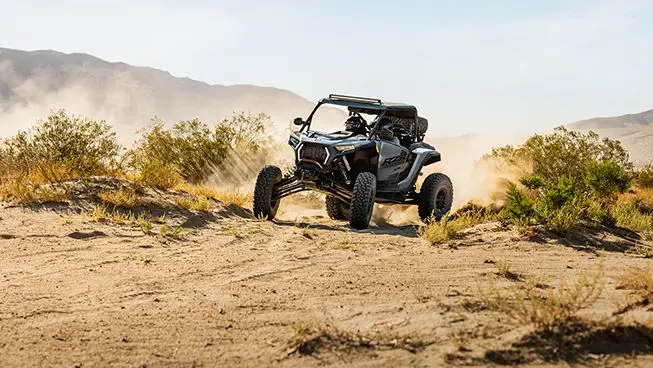 A RZR XP S side-by-side driving through the desert.