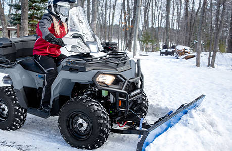 Polaris Sportsman 450 H.O. ATV with a plow and windshield installed.